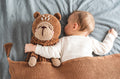 Baby sleeping with plush brown teddy toy 